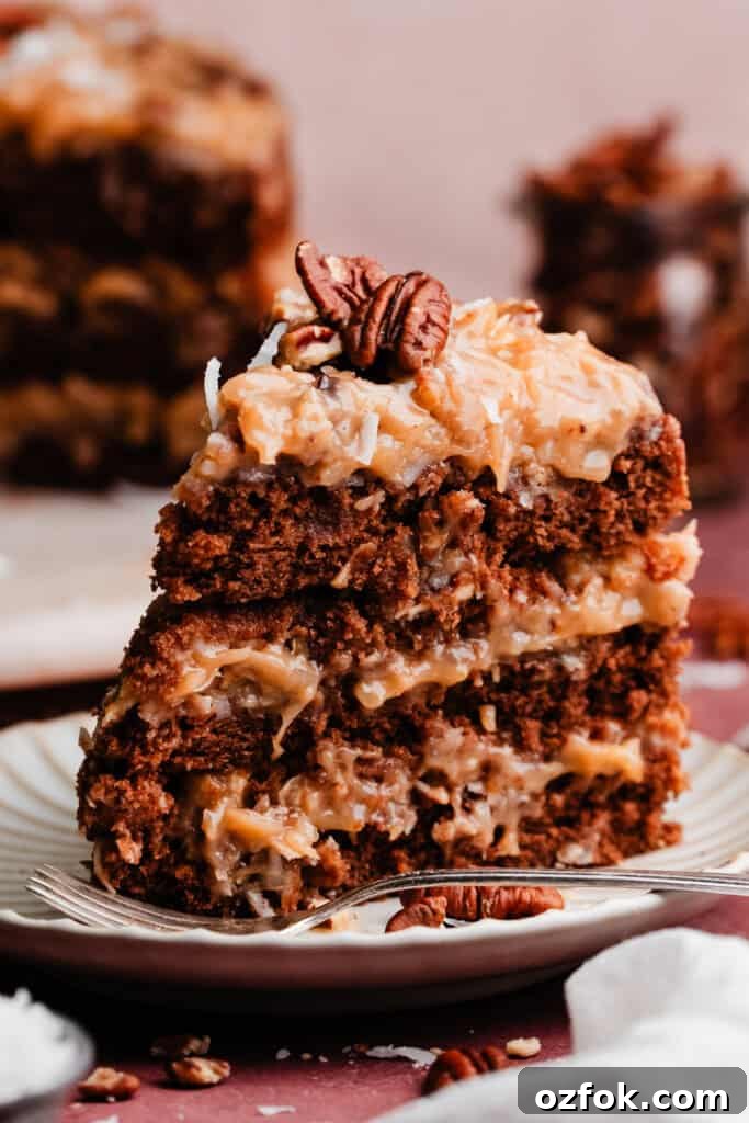Ultimate German Chocolate Cake Recipe for Rich, Layered Flavor 11 A slice of the cake standing on a cake plate.