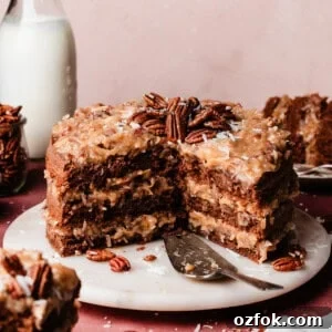 The sliced german chocolate cake on a marble cake plate.