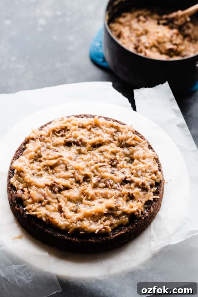 Ultimate German Chocolate Cake Recipe for Rich, Layered Flavor 9 A layer of german chocolate cake spread with the frosting.