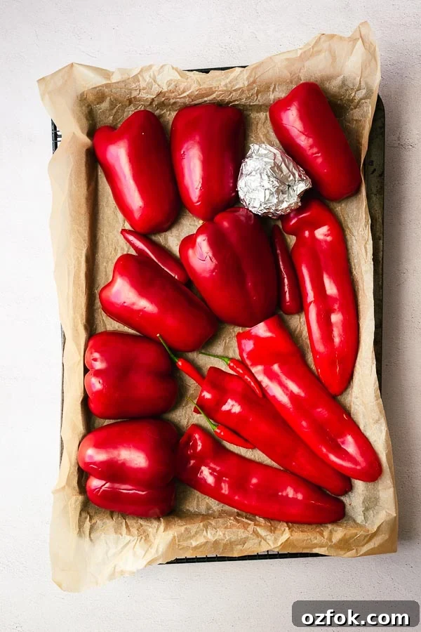 Homemade Rose Harissa Paste Recipe for Vibrant Flavor 4 Raw red peppers in a tray, ready to be roasted.