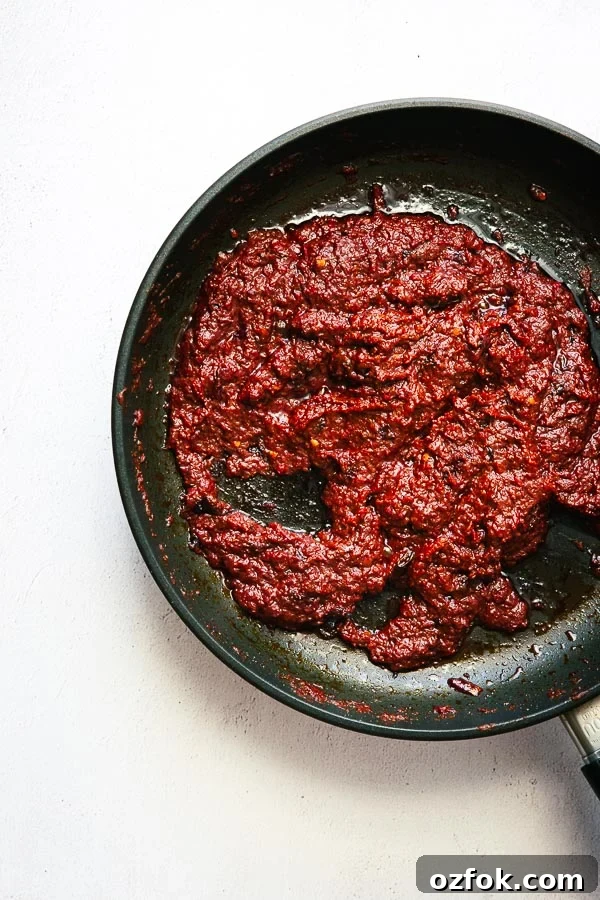 Homemade Rose Harissa Paste Recipe for Vibrant Flavor 9 Reducing harissa paste in a pan.