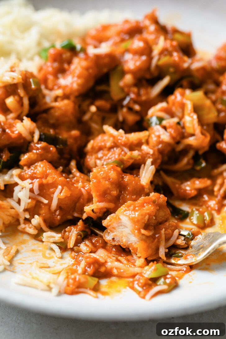 Crispy Chicken Manchurian with Tangy Gravy 12 Close up of partially eaten Chicken Manchurian with rice and a fork.