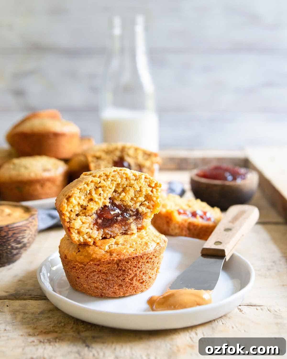 These oat based, gluten-free peanut butter and jelly muffins have a surprise strawberry jelly center and a moist, tender muffin crumb - perfect snack for kids & adults!