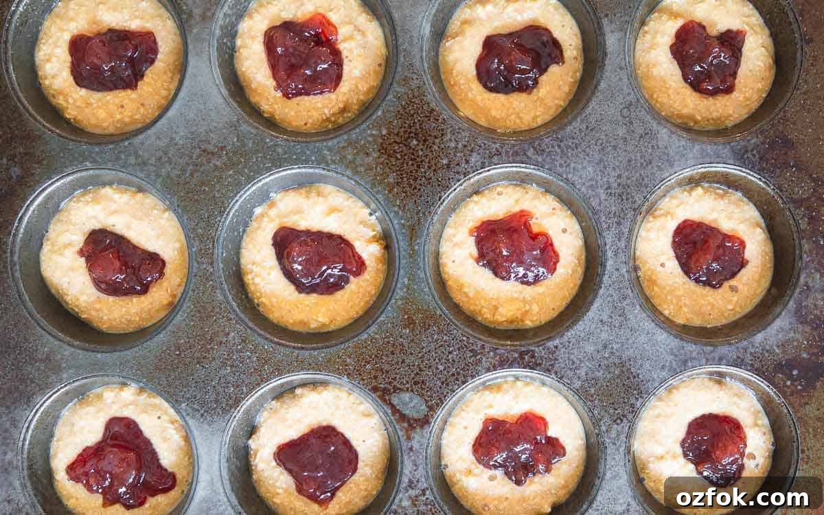Dollops of strawberry jelly hide inside the center of each peanut butter muffin