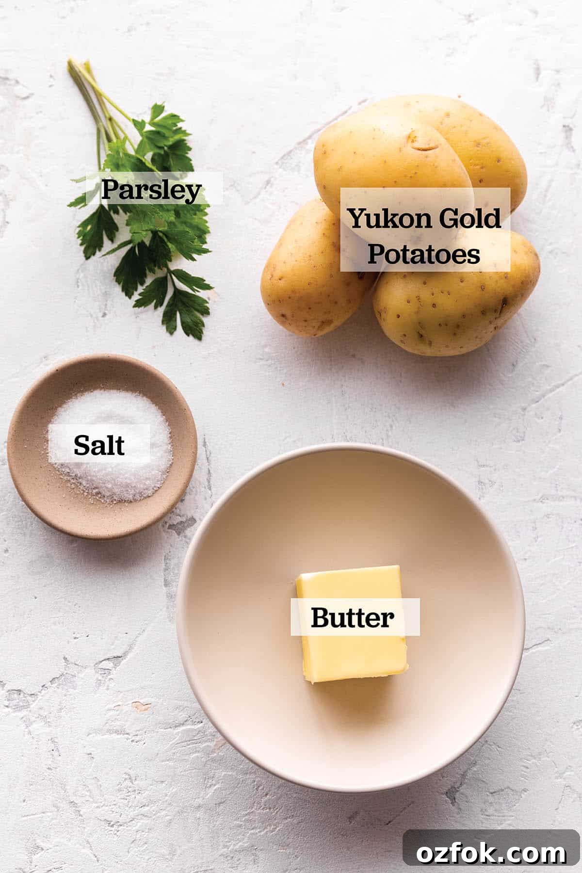A plate with butter, yukon potatoes, parsley and salt.