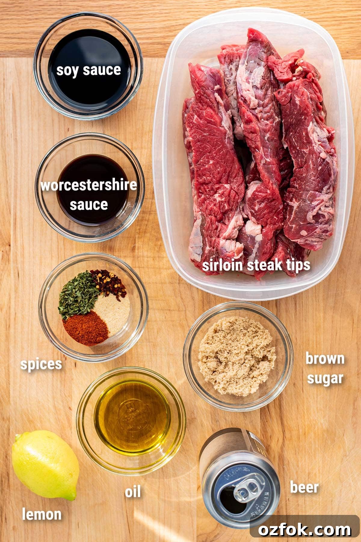 Beer Teriyaki Marinated Steak Tips for Grilling or Pan-Searing 3 Raw, uncooked steak tips and homemade teriyaki marinade ingredients laid out on a wooden cutting board.