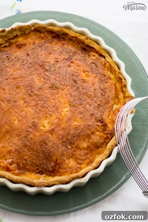 Grandma’s Incredible Ham and Cheese Quiche Recipe 6 Gran's ham and cheese quiche in a white baking dish on a green plate.
