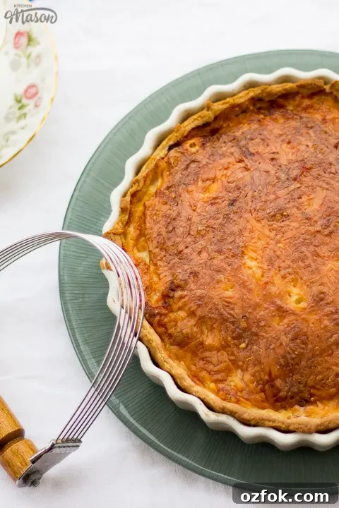 Grandma’s Incredible Ham and Cheese Quiche Recipe 12 Gran's ham and cheese quiche in a white baking dish on a green plate.