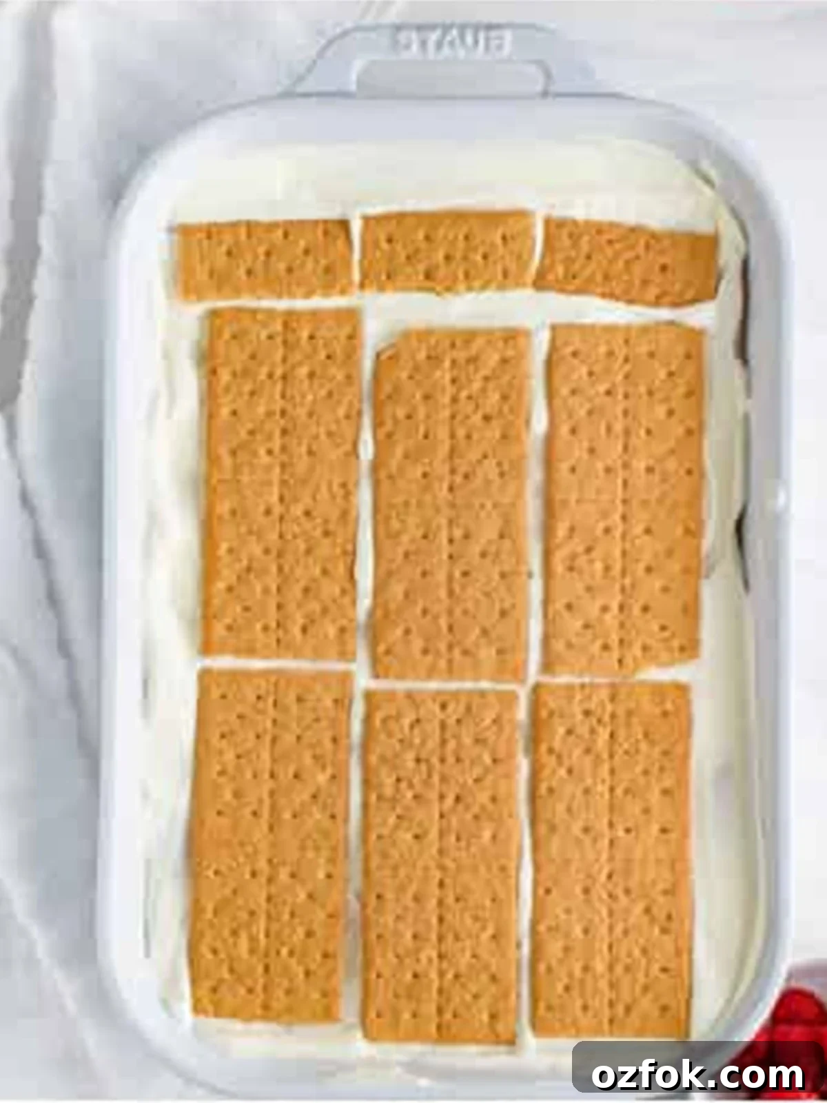 No-Bake Raspberry Icebox Cake Recipe for Summer Parties 14 Final graham cracker layer added before the last cream layer on Raspberry Icebox Cake.