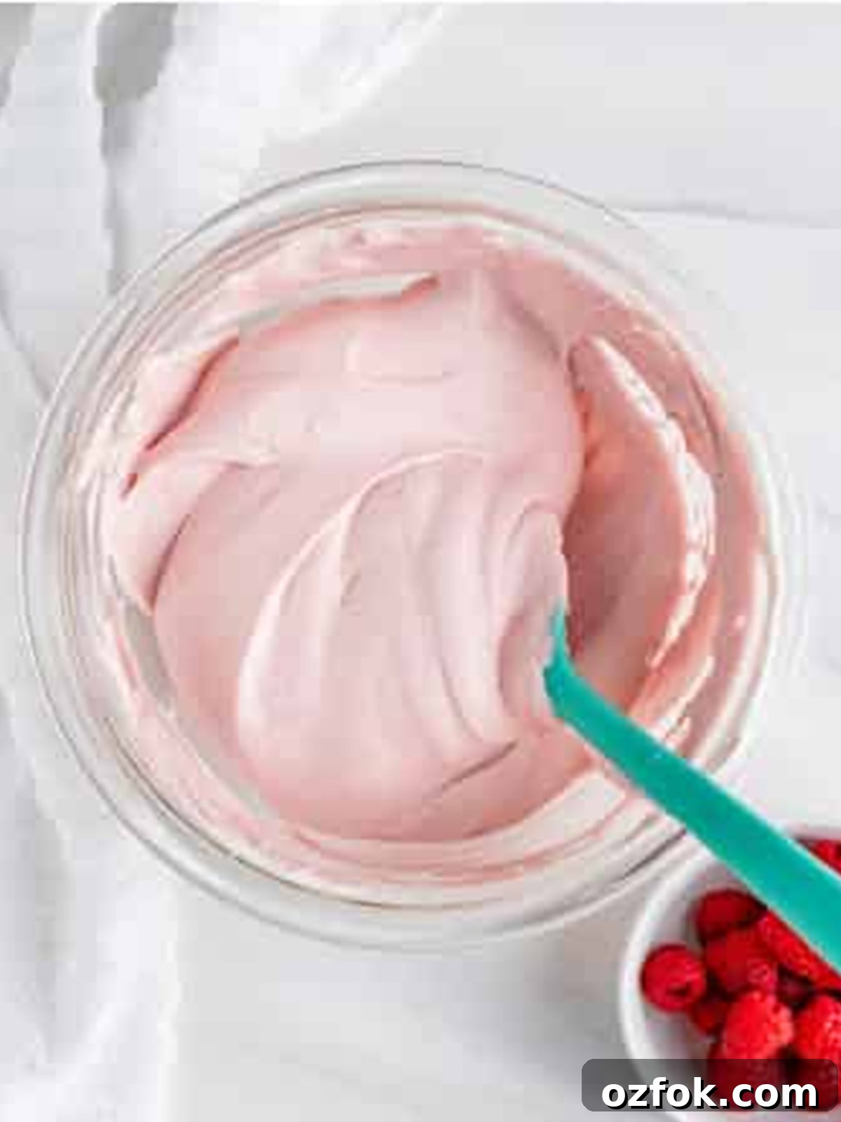 No-Bake Raspberry Icebox Cake Recipe for Summer Parties 5 Raspberry preserves folded into whipped cream making pink cream for Raspberry Icebox Cake.