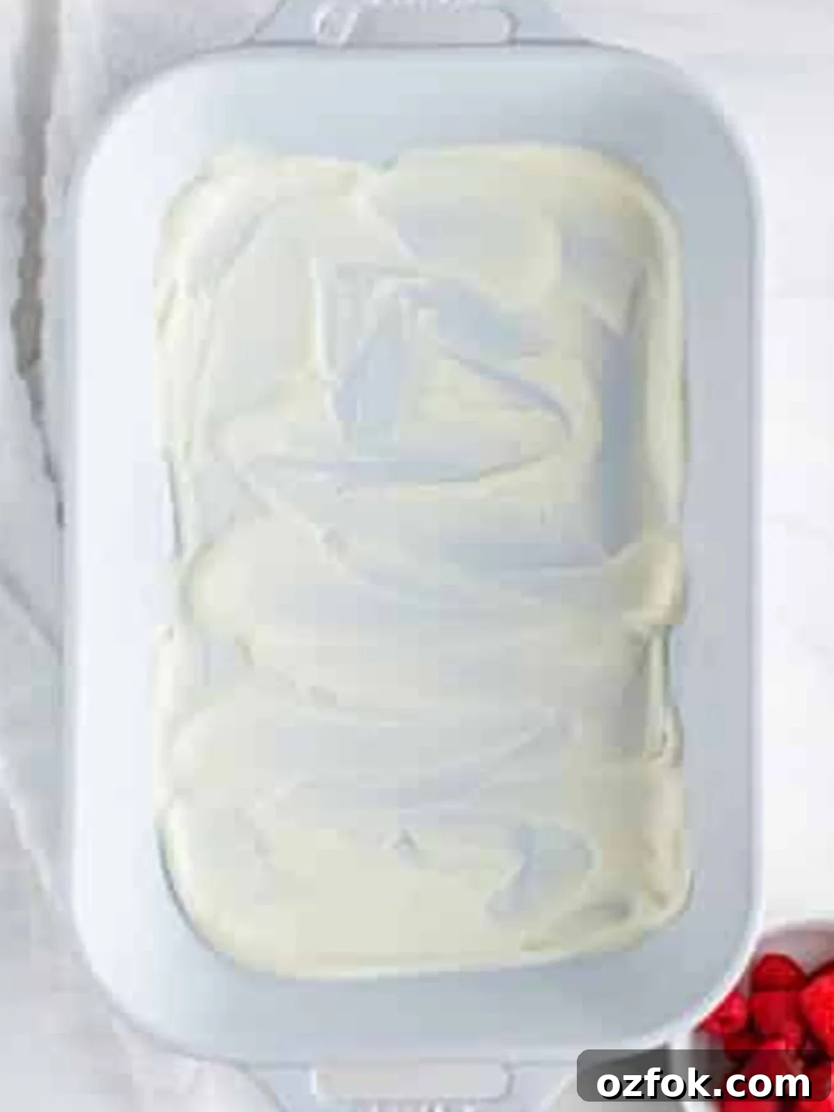 No-Bake Raspberry Icebox Cake Recipe for Summer Parties 7 Plain whipped cream spread over the bottom of a 9x13 dish for Raspberry Icebox Cake.