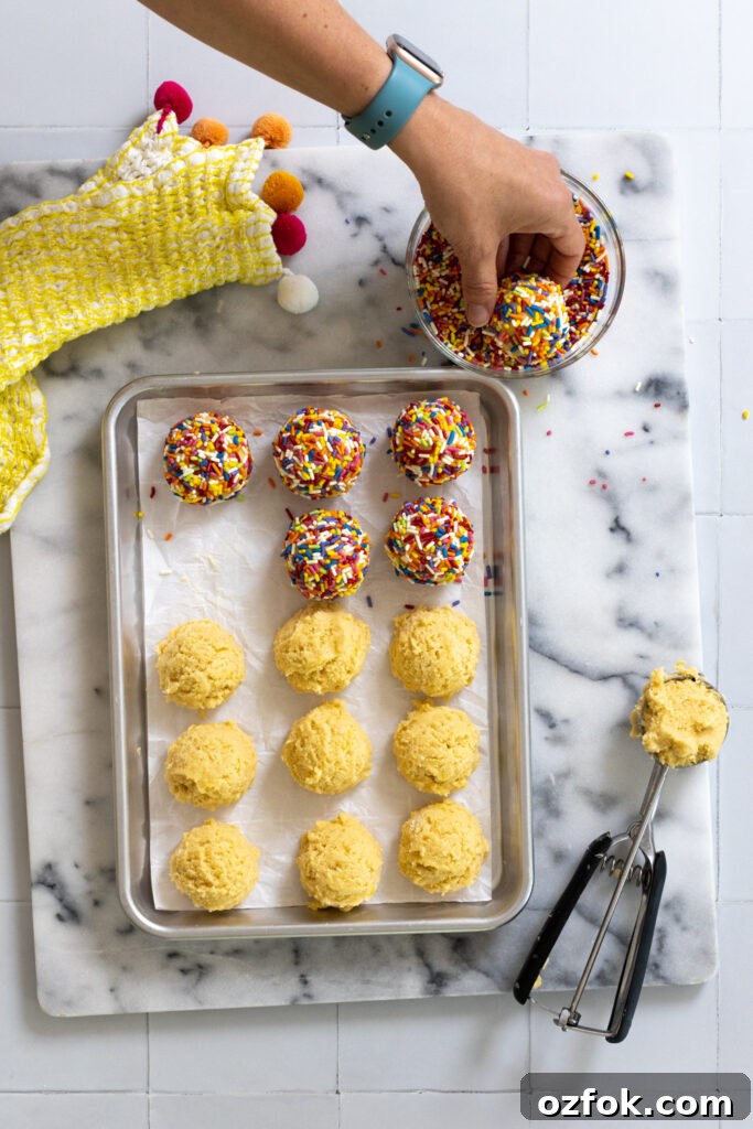 Lemon Rainbow Sprinkle Cookies Recipe — Bright Citrus Sugar Cookies 17 Rolling lemon cookies in rainbow sprinkles