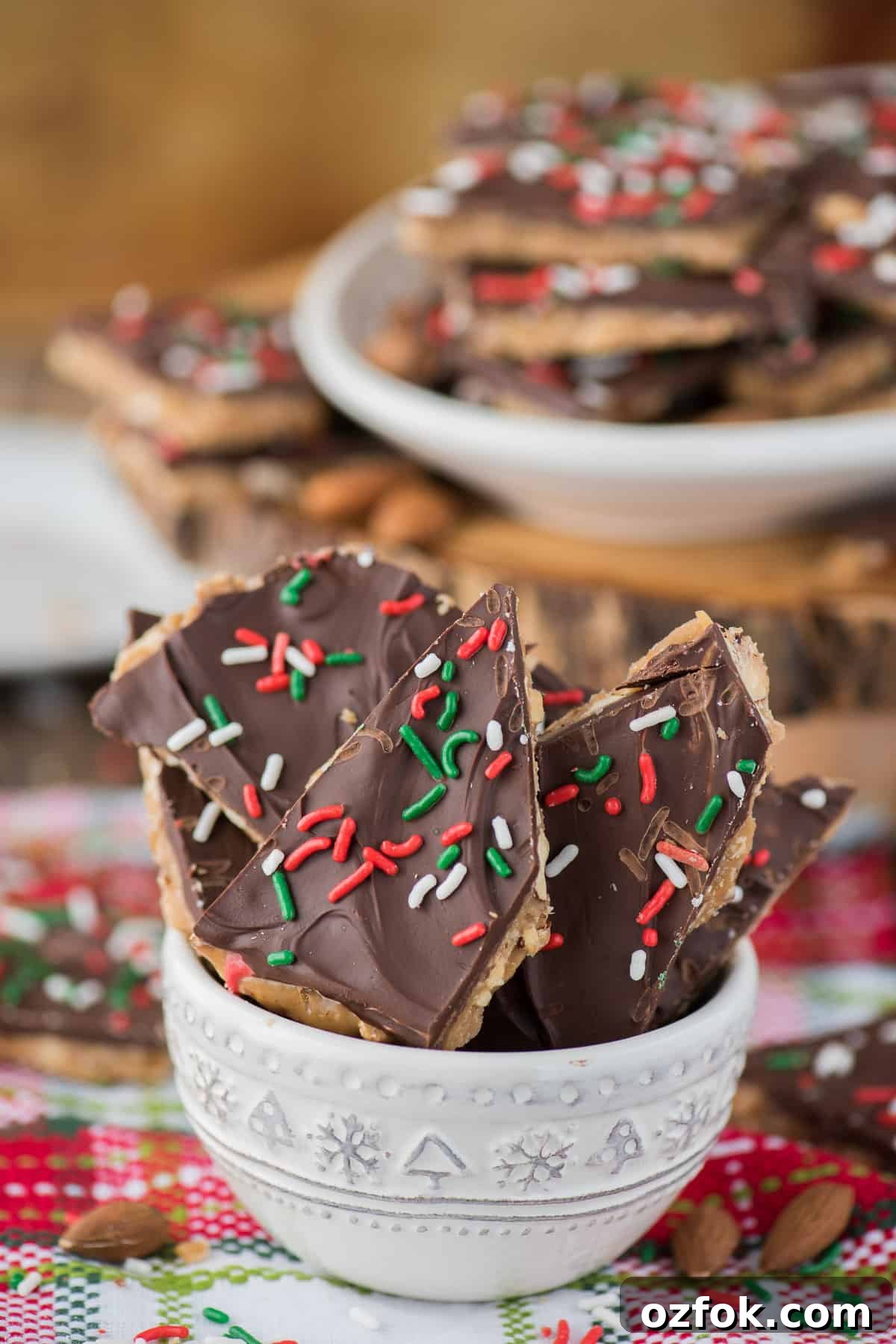 How to make homemade english toffee including directions with and without a candy thermometer. This is the MEGA post on toffee! So many tips, everything you’ve wanted to know about making Christmas toffee at home! english toffee with christmas sprinkles stacked in a white bowl
