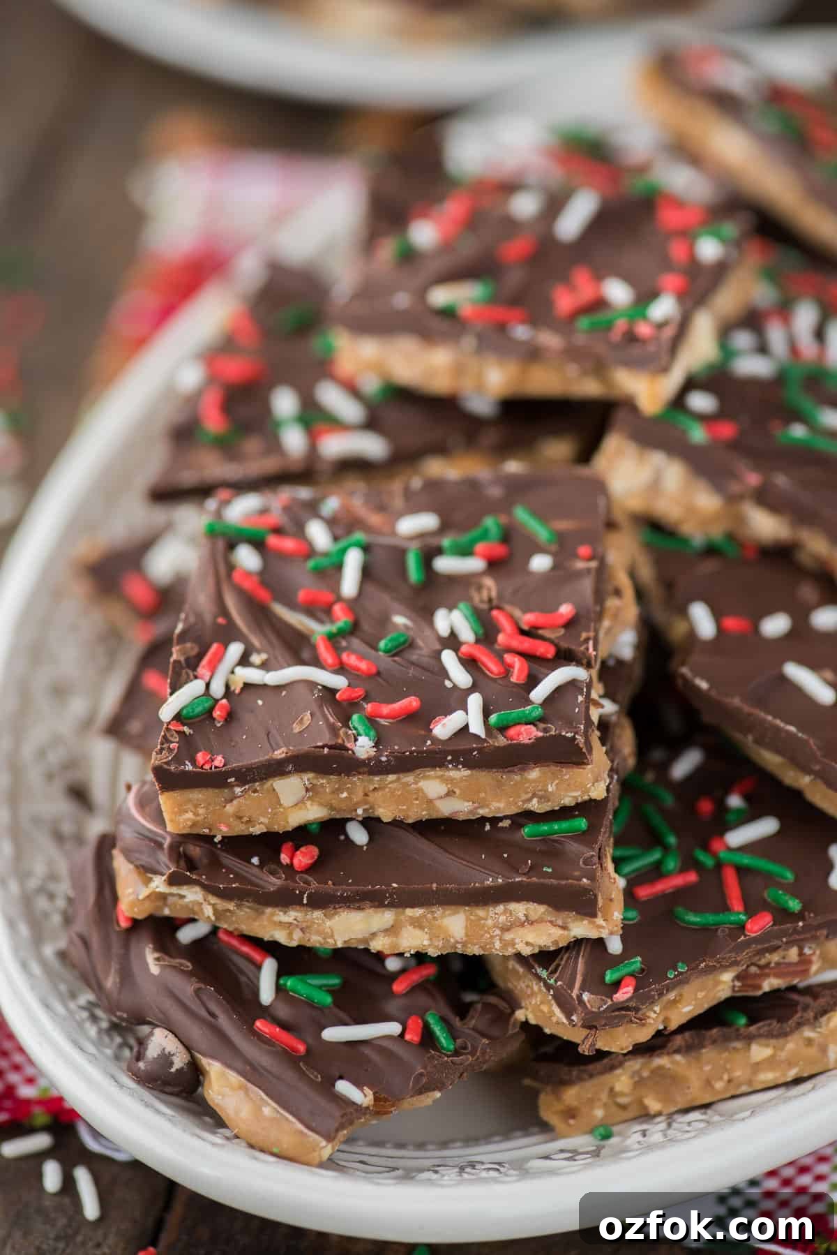 How to make homemade english toffee including directions with and without a candy thermometer. This is the MEGA post on toffee! So many tips, everything you’ve wanted to know about making Christmas toffee at home! english toffee with christmas sprinkles stacked on a white plate