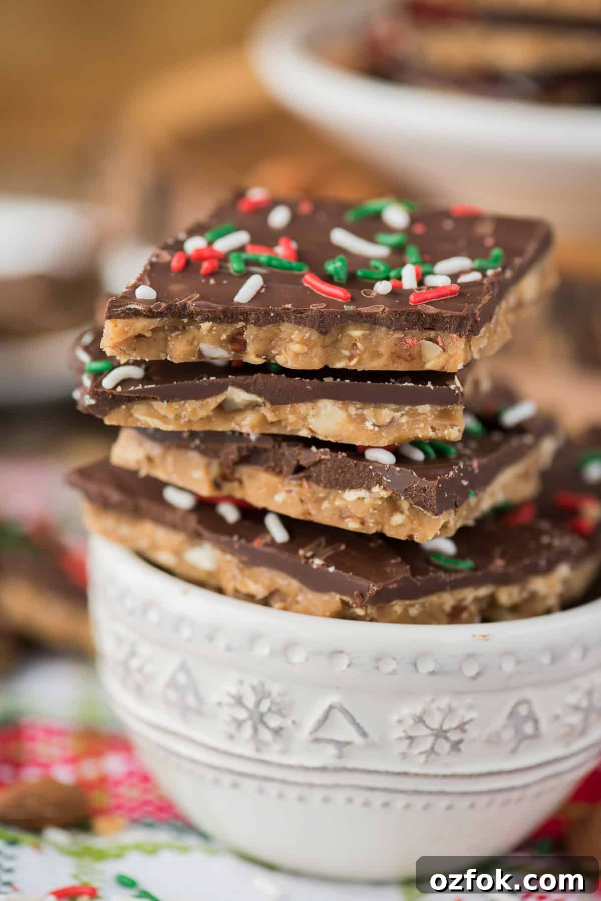 How to make homemade english toffee including directions with and without a candy thermometer. This is the MEGA post on toffee! So many tips, everything you’ve wanted to know about making Christmas toffee at home! english toffee with christmas sprinkles stacked in a white bowl