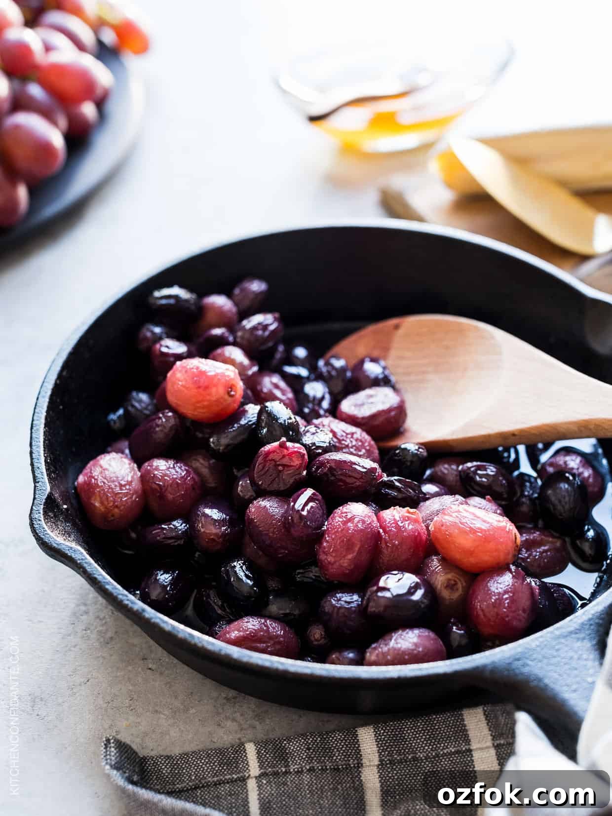 Caramelized Grape, Brie & Walnut Crostini Bites for Entertaining 4 Stirring caramelized grapes with a wooden spoon in a cast iron pan.