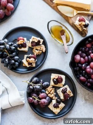 Caramelized Grape, Brie & Walnut Crostini Bites for Entertaining 8 Caramelized Grape, Brie and Walnut Bites made with TRISCUIT crackers and served on dark plates.