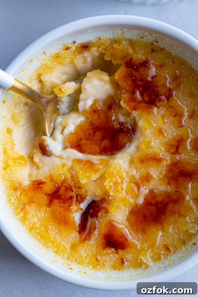 A spoon in a small bowl with Crème Brûlée.