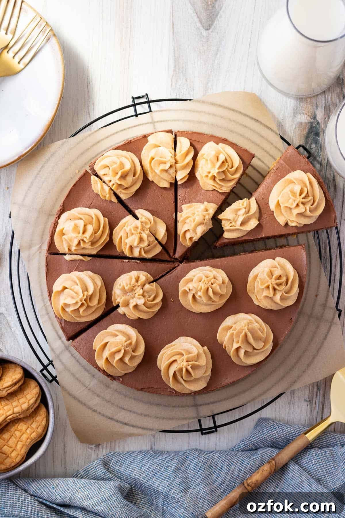 No-Bake Chocolate Peanut Butter Cheesecake Recipe 2 chocolate peanut butter cheesecake on top of a black wire cooling rack with a bowl of peanut butter cookies next to it