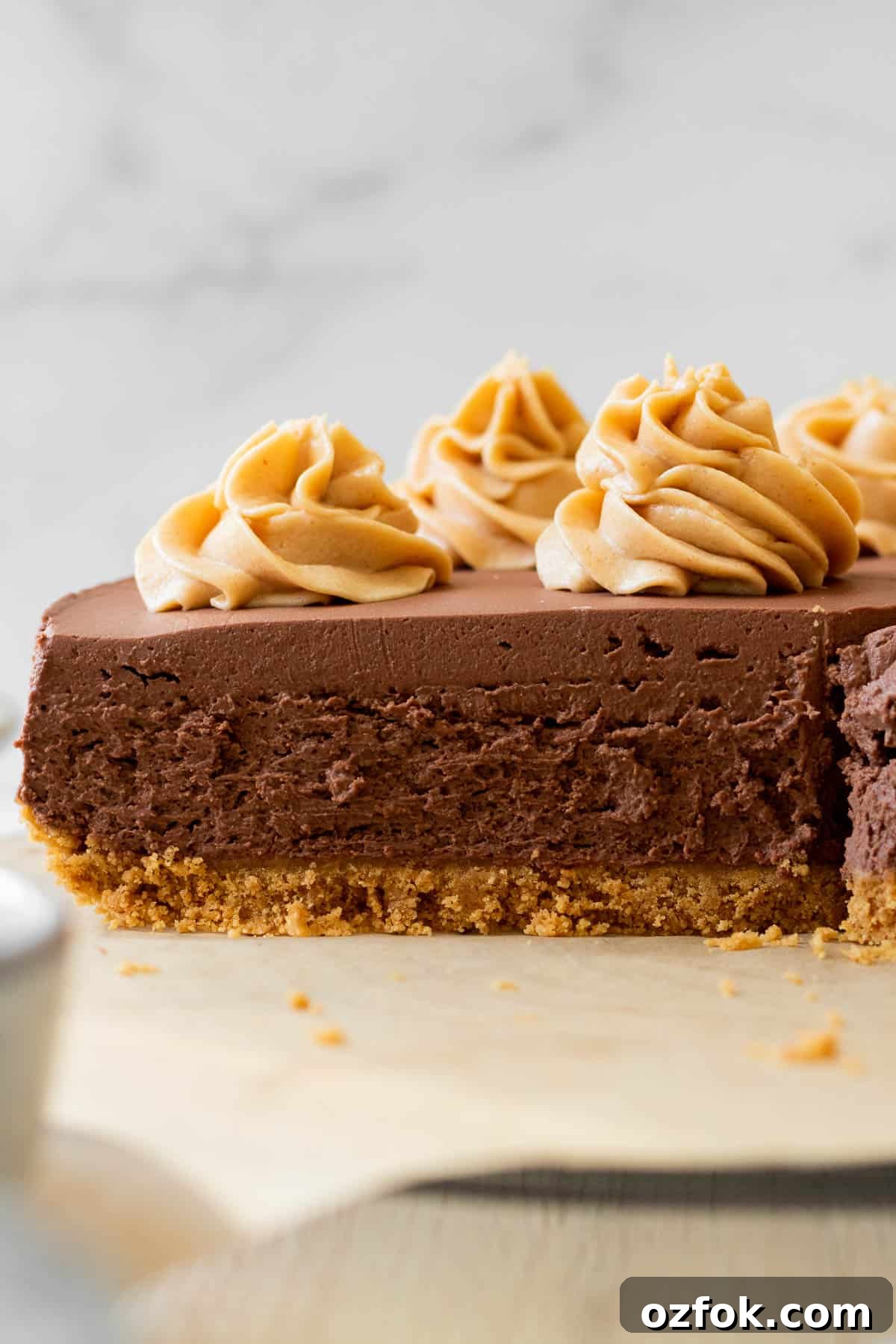 No-Bake Chocolate Peanut Butter Cheesecake Recipe 3 sliced chocolate cheesecake with peanut butter swirls on top