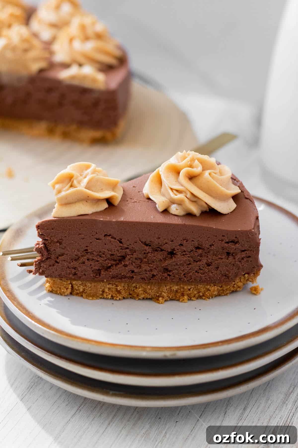 No-Bake Chocolate Peanut Butter Cheesecake Recipe 5 slice of chocolate peanut butter no-bake cheesecake on a white plate with a golf fork