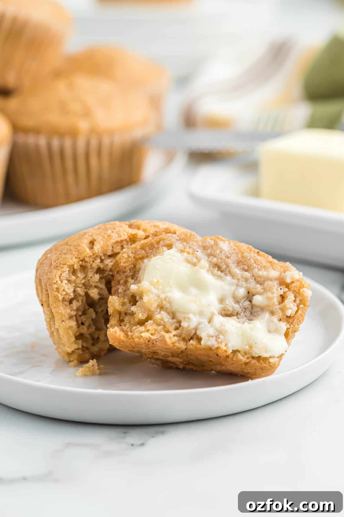 Moist Applesauce Muffins with Warm Cinnamon Sugar Topping 13 applesauce muffin cut open with butter smeared on it