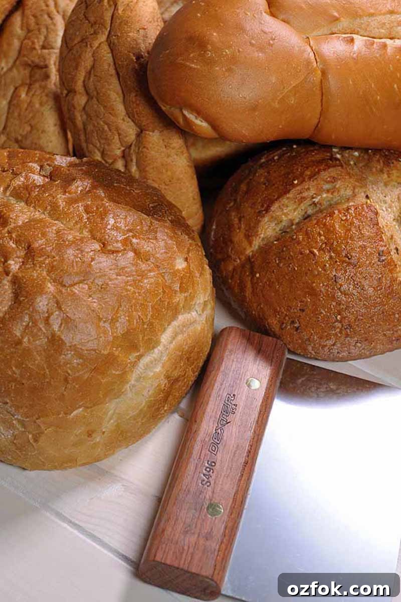 Top Bread Baking Tools Trusted by Foodal 5 Vertical image of assorted baked goods next to a metal bench scraper.