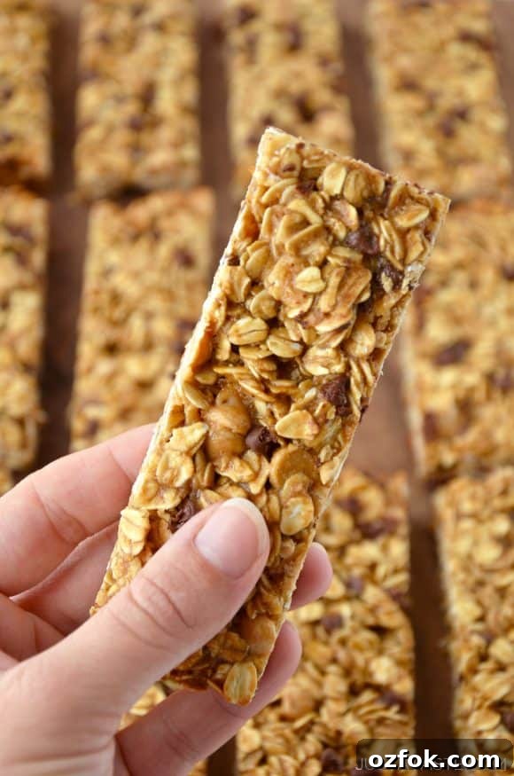Homemade Peanut Butter Granola Bars Recipe – Chewy No-Bake Snack 7 Holding a Homemade Peanut Butter Granola Bar with more granola bars in the background