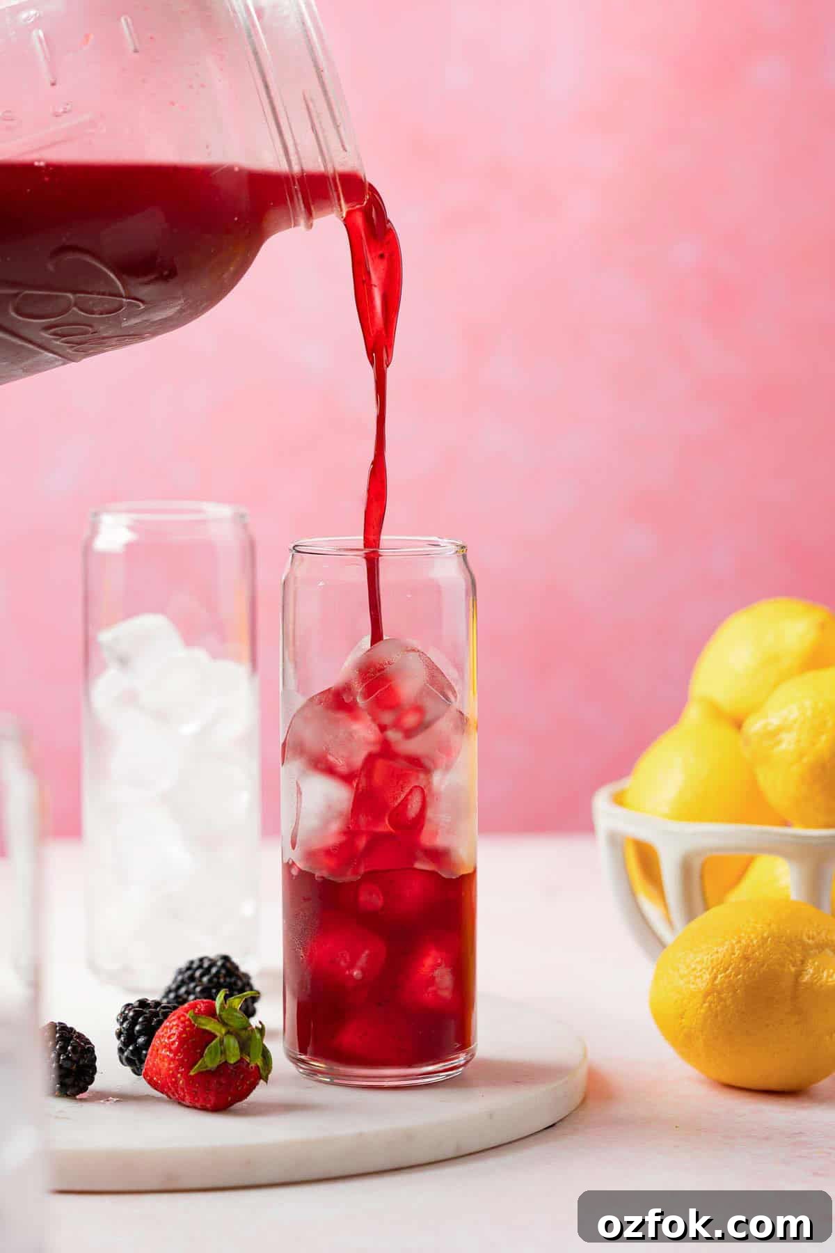 Refreshing Berry Lemonade Recipe: Bright Summer Drink Guide 10 jug of berry lemonade being poured into a glass filled with ice.