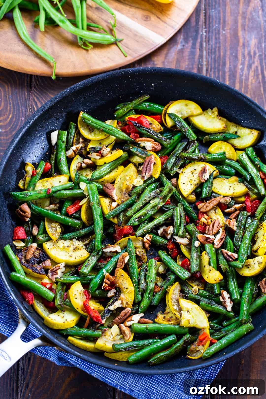 Sautéed Green Beans and Yellow Squash with Garlic and Lemon 3 Green beanns and squash in skillet with pecans.