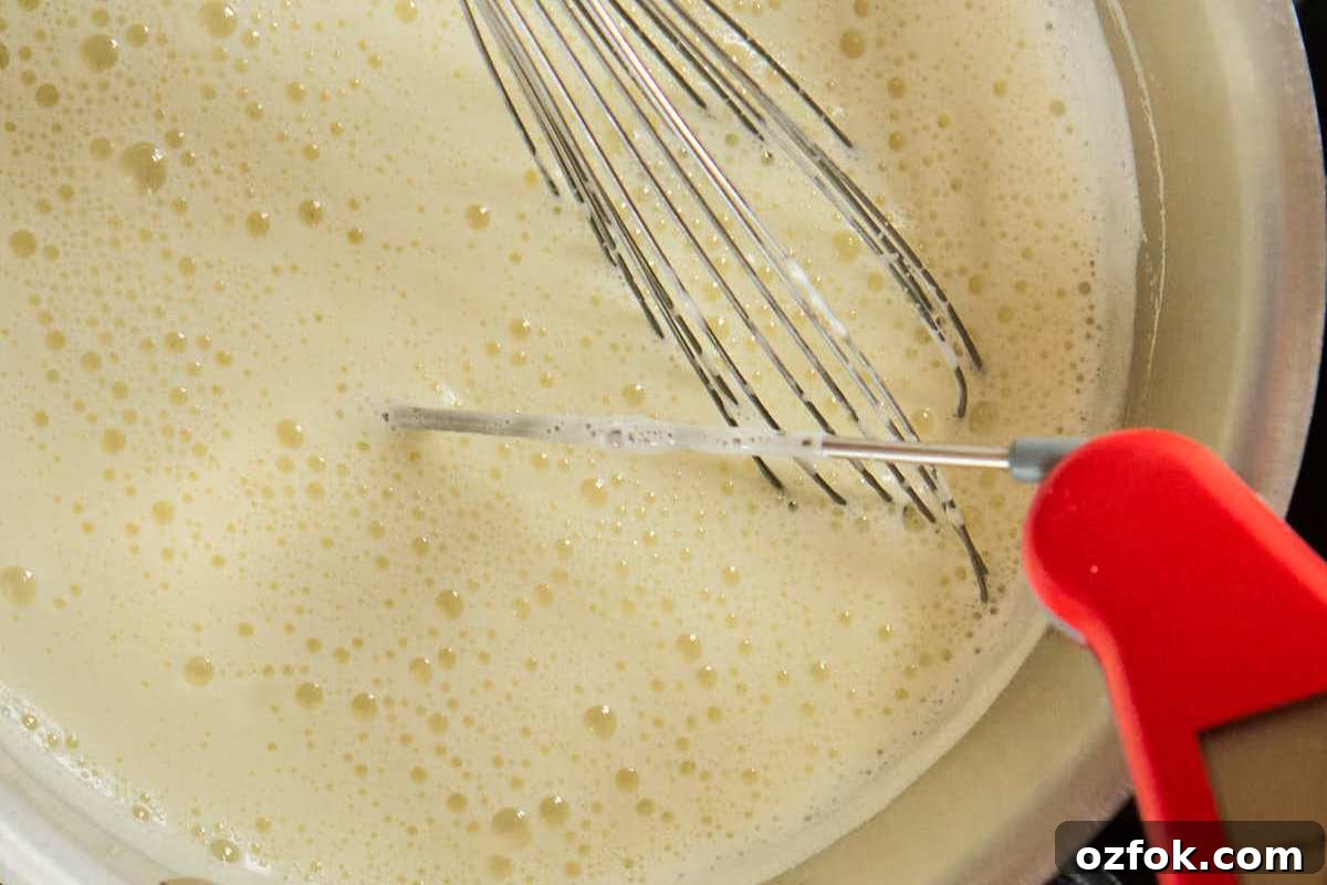 Classic Homemade Vanilla Ice Cream Recipe 7 custard heating in pan with thermometer.