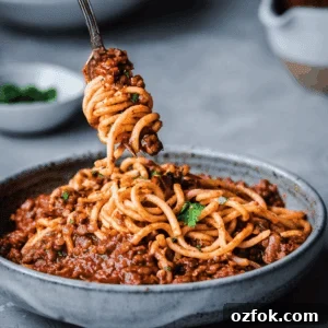 red lentil bolognese twirling on a fork