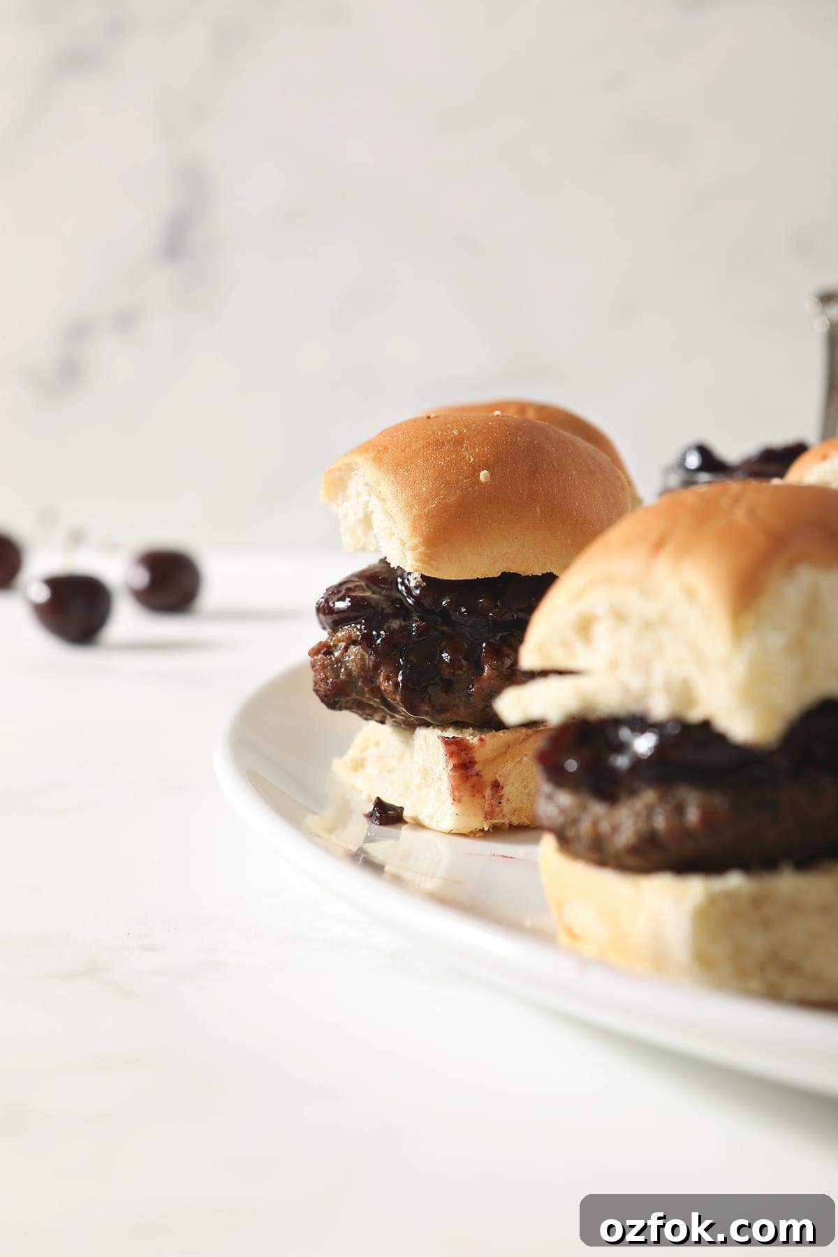 20+ Fourth of July Grilling Recipes for Your Backyard BBQ 11 Hamburger sliders with Bacon Cherry Compote sit on a white platter before serving