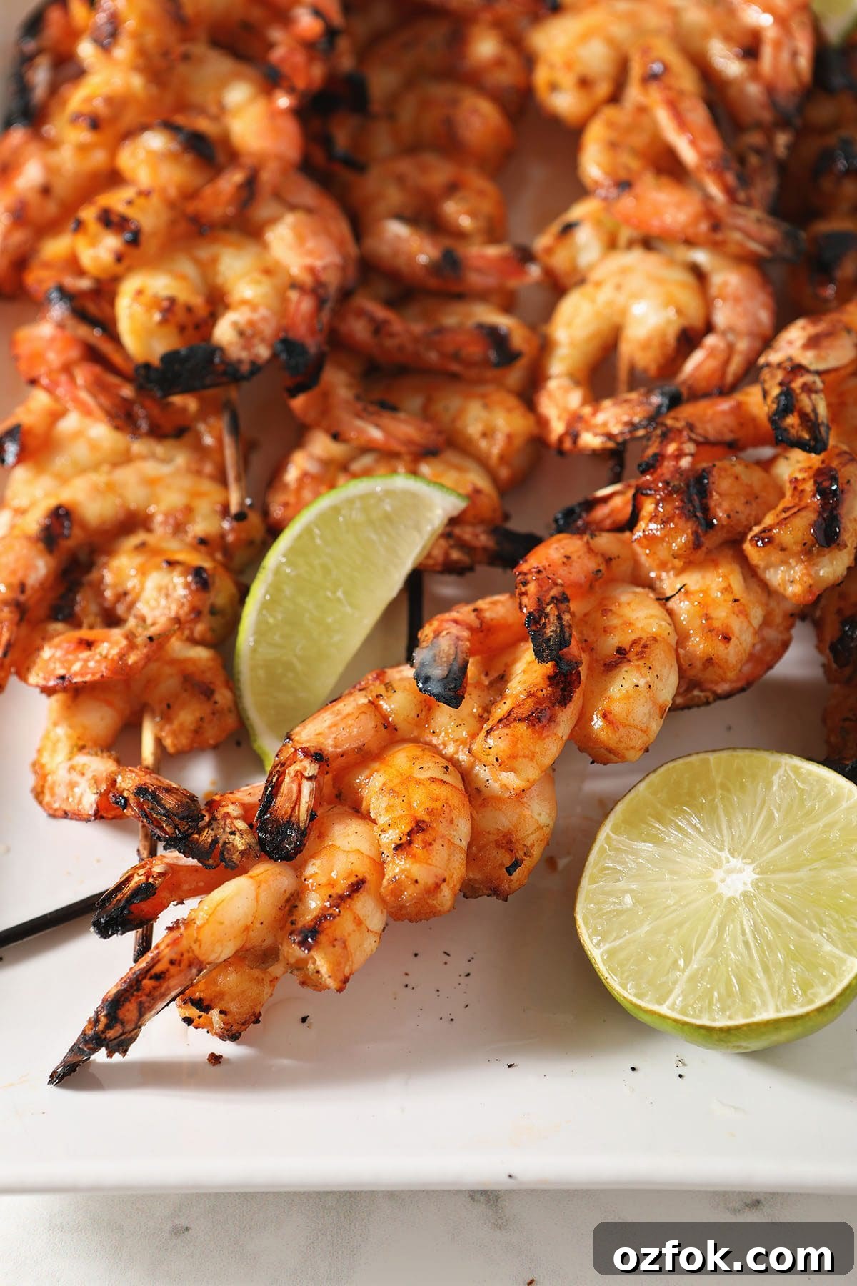 20+ Fourth of July Grilling Recipes for Your Backyard BBQ 5 Skewers of shrimp on a white plate