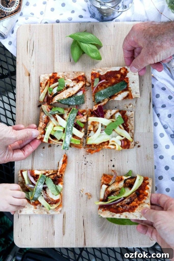 20+ Fourth of July Grilling Recipes for Your Backyard BBQ 7 Four people grab for slices of Grilled BBQ Chicken Flatbread, straight off the grill