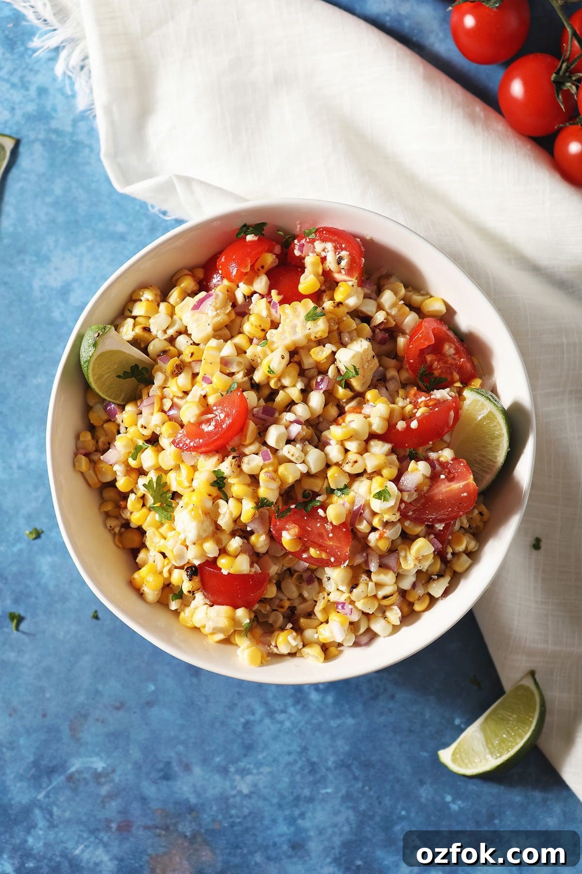 20+ Fourth of July Grilling Recipes for Your Backyard BBQ 9 A bowl of corn salsa with tomatoes and limes on a blue countertop