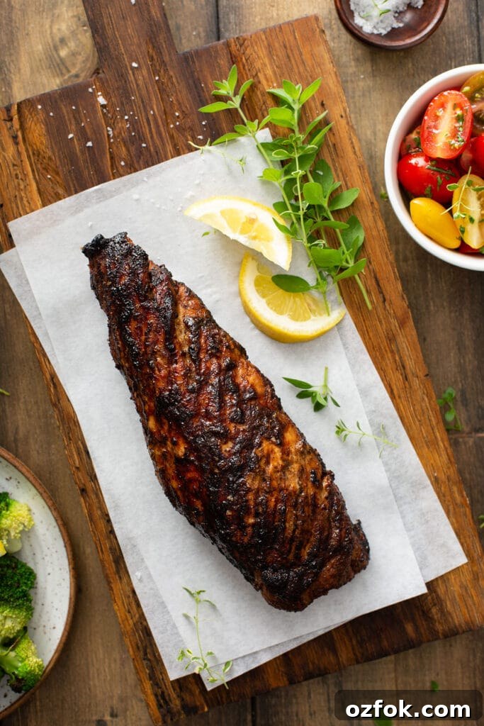 A pork tenderloin roast grilled on a cutting board