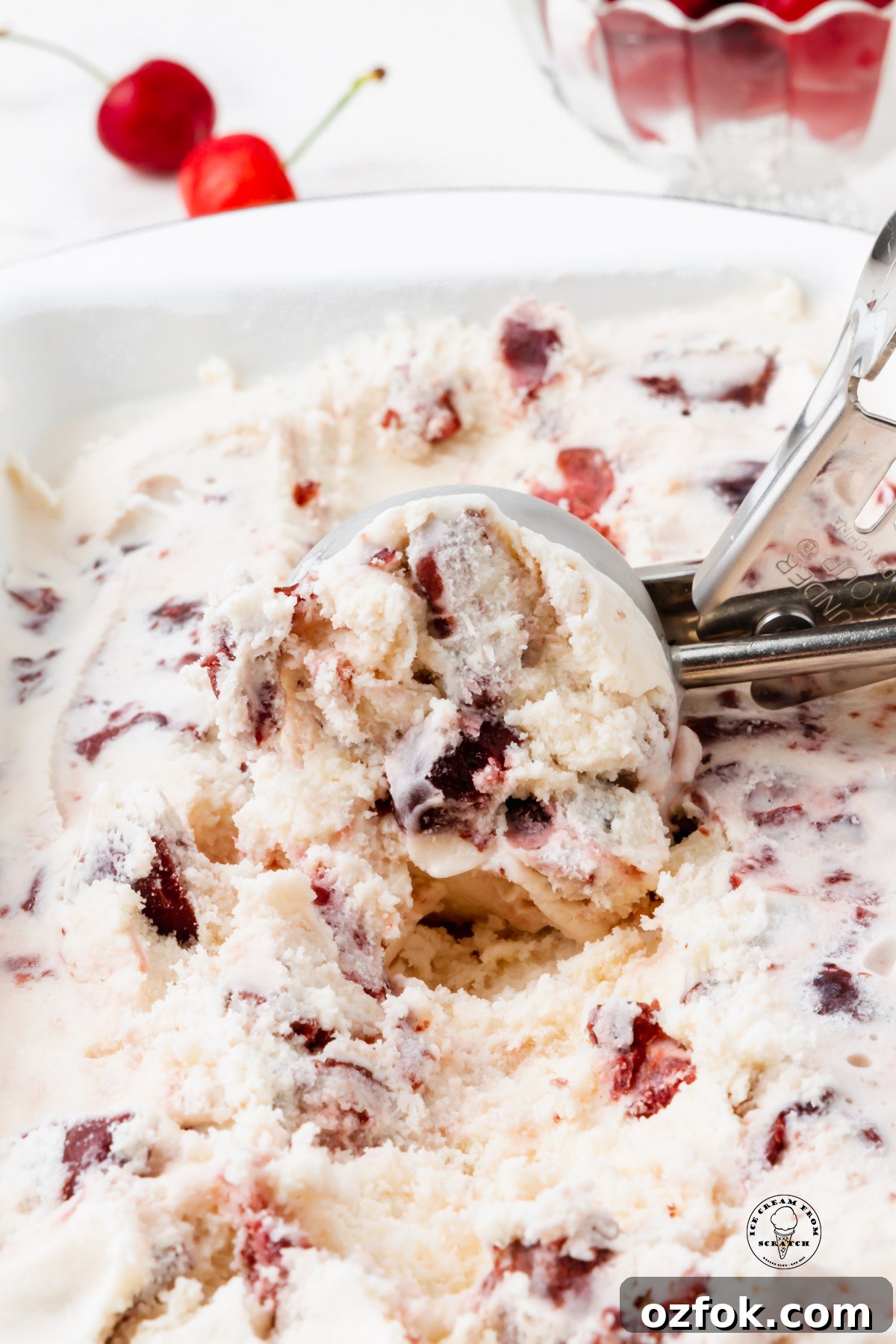 Cherry Gelato Recipe: Creamy Homemade Cherry Gelato Guide 5 a metal scoop brining up a scoop of homemade cherry gelato from a pan.