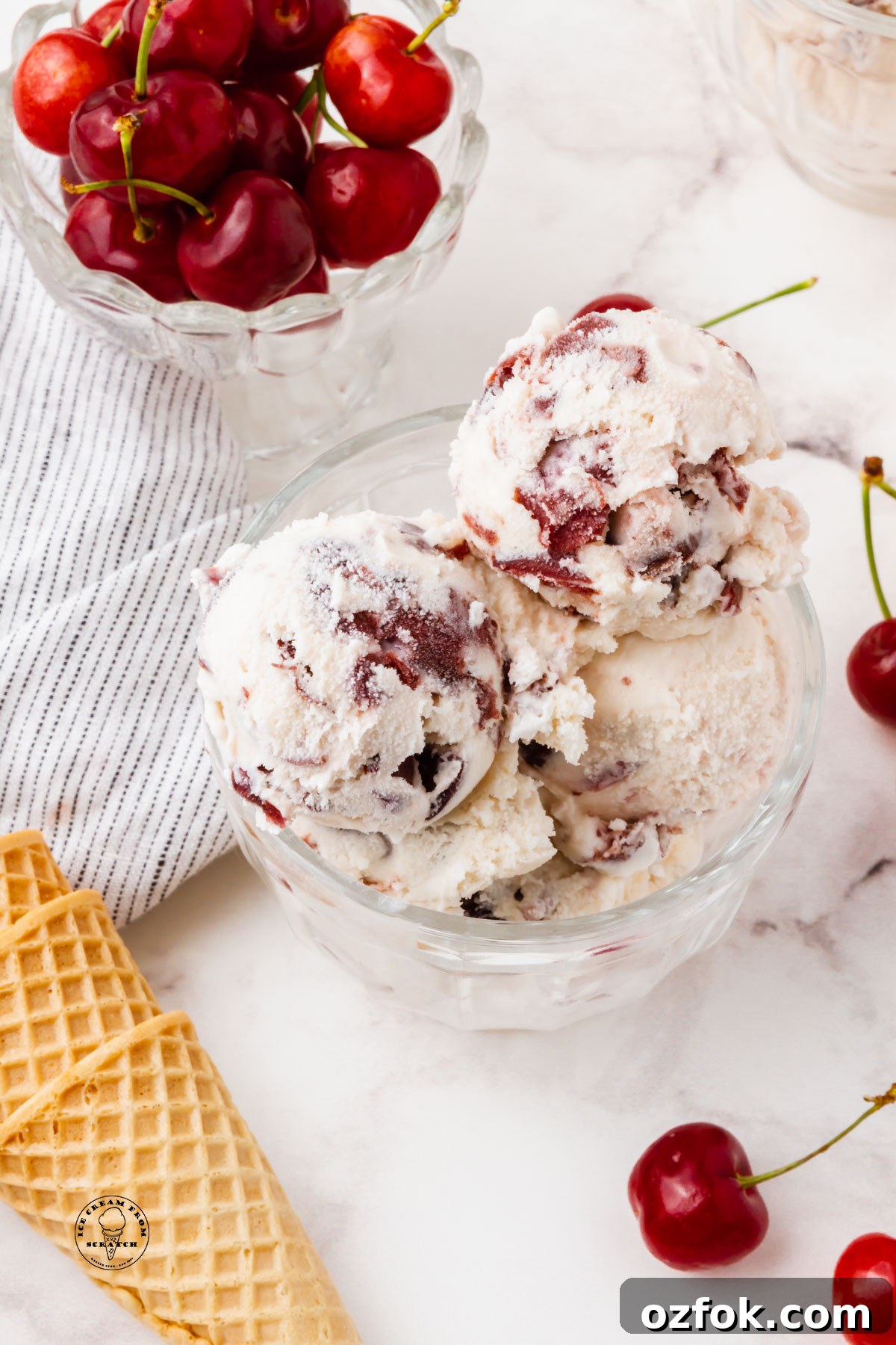 Cherry Gelato Recipe: Creamy Homemade Cherry Gelato Guide 6 a glass bowl filled with scoops of cherry gelato, next to a bowl of fresh cherries and sugar cones.