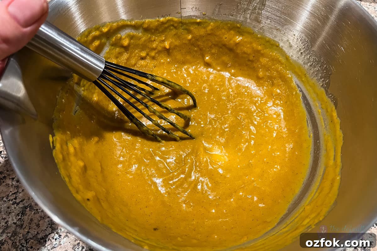 Wet ingredients fully mixed in a medium bowl with a small whisk.
