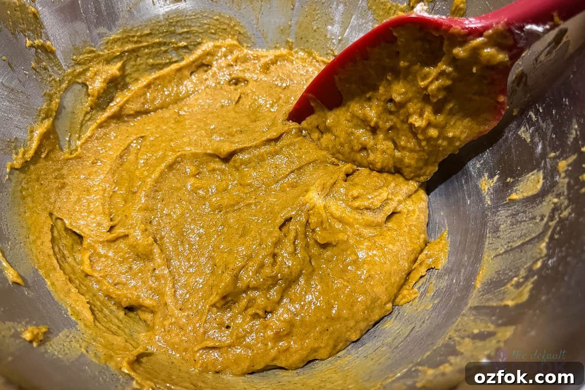 Mixed batter with a spatula still in it, batter has some lumps but no visible flour.