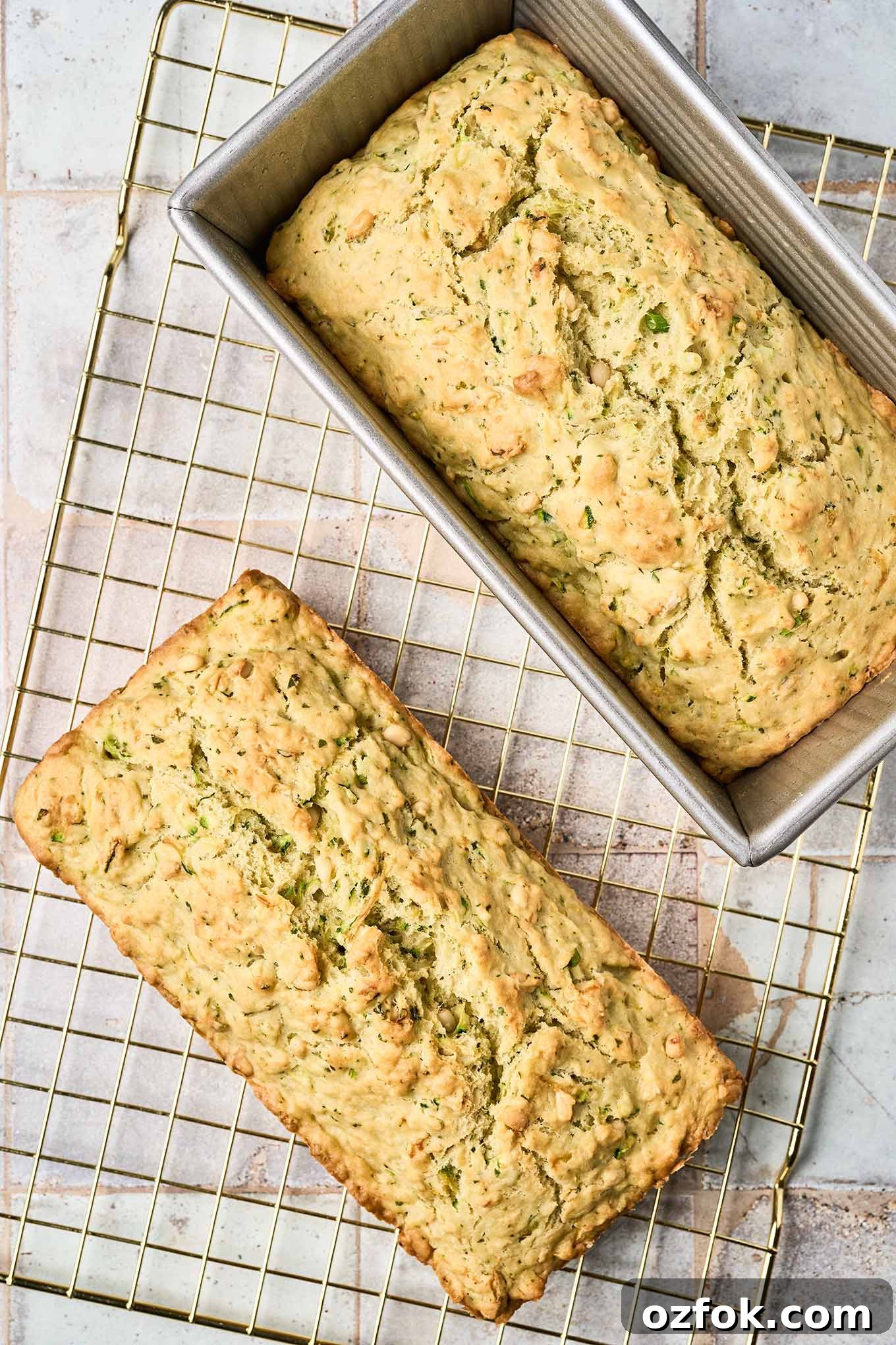 Cooling - the final step in making savory zucchini bread, one loaf directly on a cooling rack, the other still cooling in the pan.