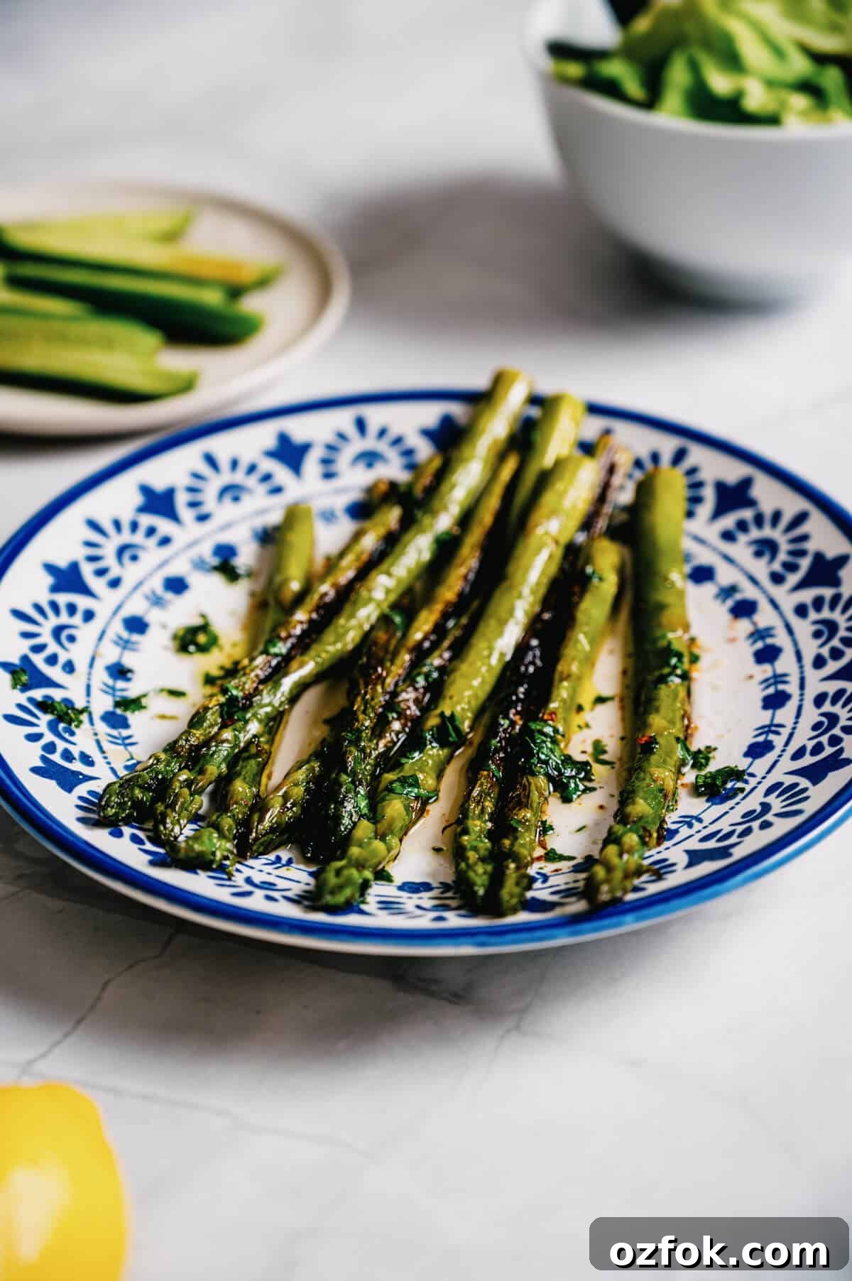 Foil-Grilled Asparagus with Lemon and Garlic 12 a white and blue plate filled with grilled asparagus.