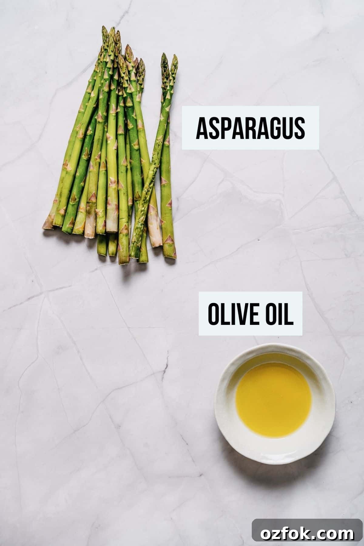 Foil-Grilled Asparagus with Lemon and Garlic 3 ingredients for grilled asparagus on a white marble table.