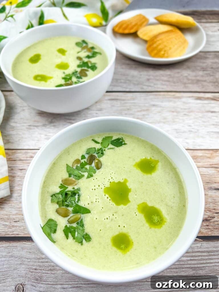 Creamy Jalapeño Soup Recipe: Smooth, Spicy, and Cozy 2 Two bowls of Cream of Jalapeno Soup with cornbread madeleines in the background.