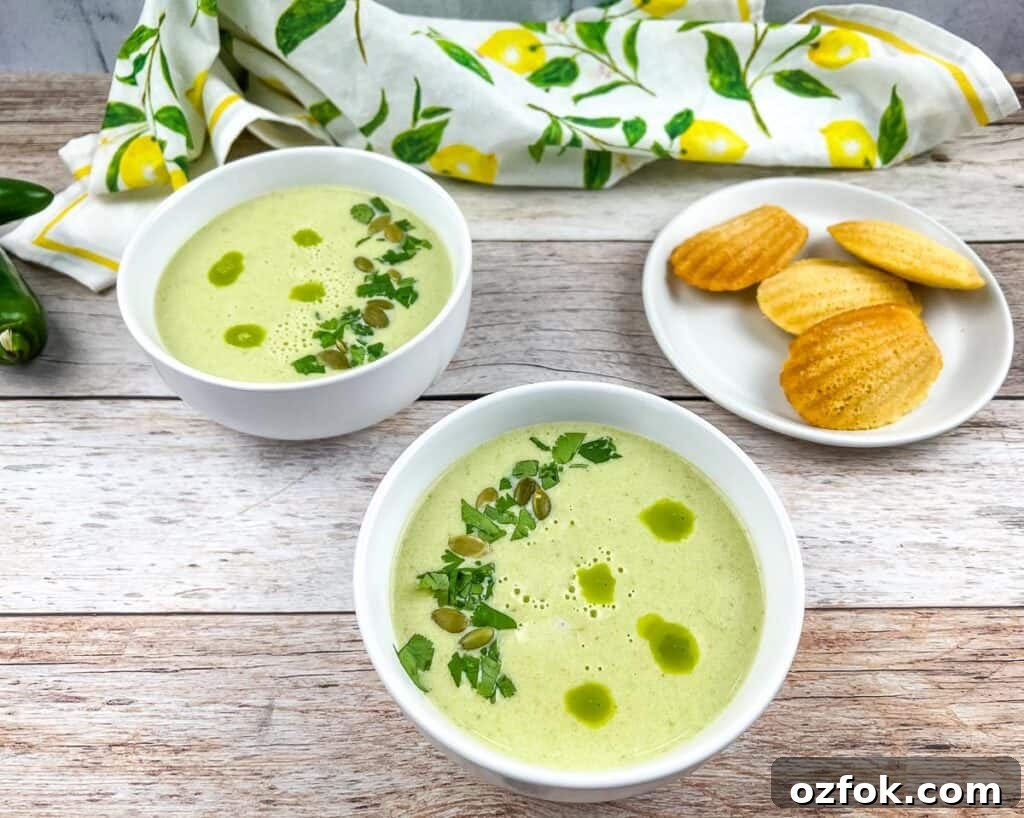 Creamy Jalapeño Soup Recipe: Smooth, Spicy, and Cozy 3 Two bowls of Cream of Jalapeno Soup with cornbread madeleines in the background.