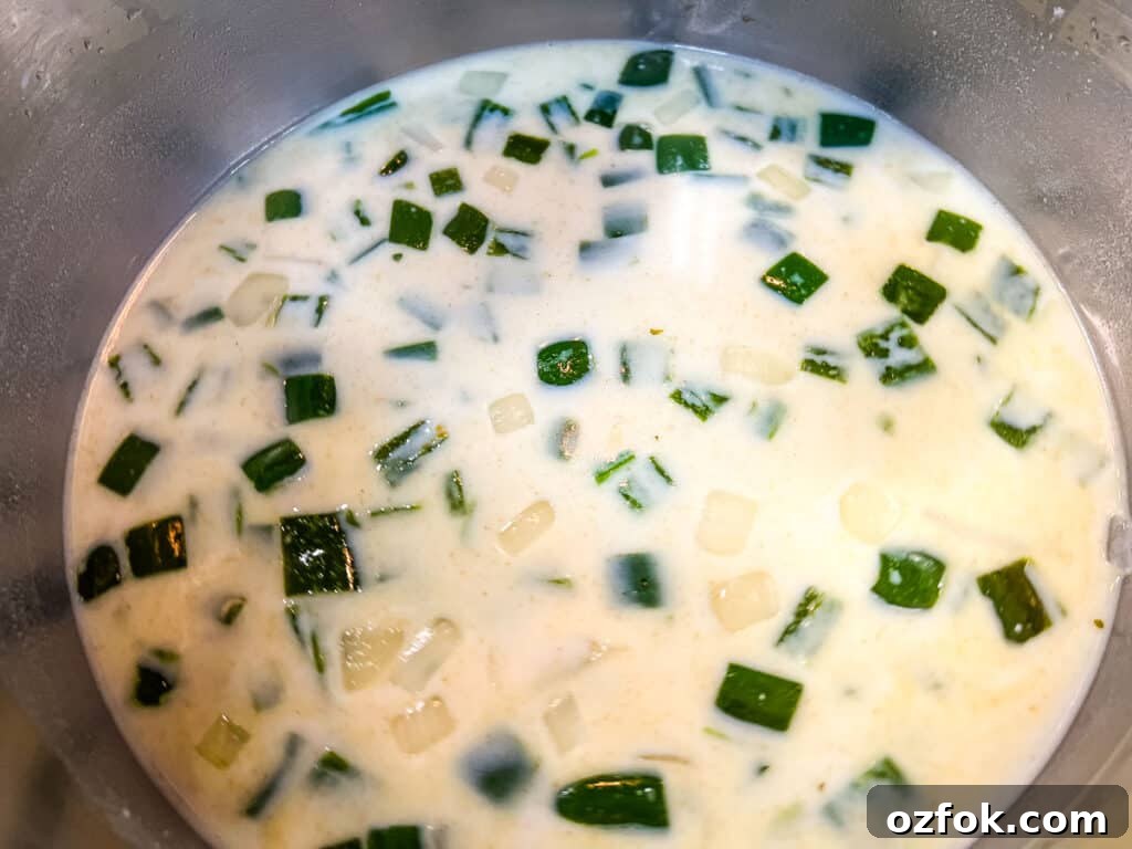 Creamy Jalapeño Soup Recipe: Smooth, Spicy, and Cozy 7 Simmering the soup with broth and milk.