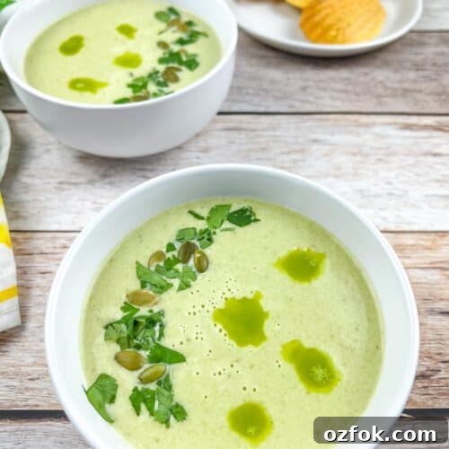 Creamy Jalapeño Soup Recipe: Smooth, Spicy, and Cozy 9 Two bowls of Cream of Jalapeno Soup with cornbread madeleines in the background.