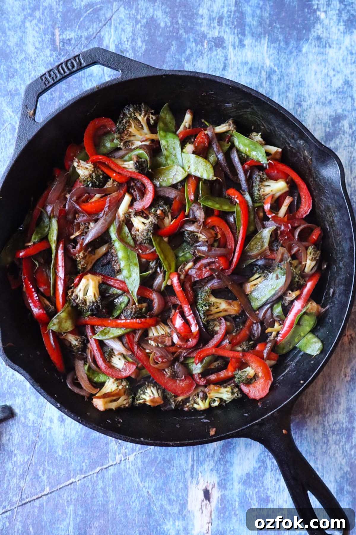 Shrimp and Steak Stir-Fry Recipe for Fast Weeknight Meals 5 cast iron skillet with peppers, broccoli, onion, and snow peas