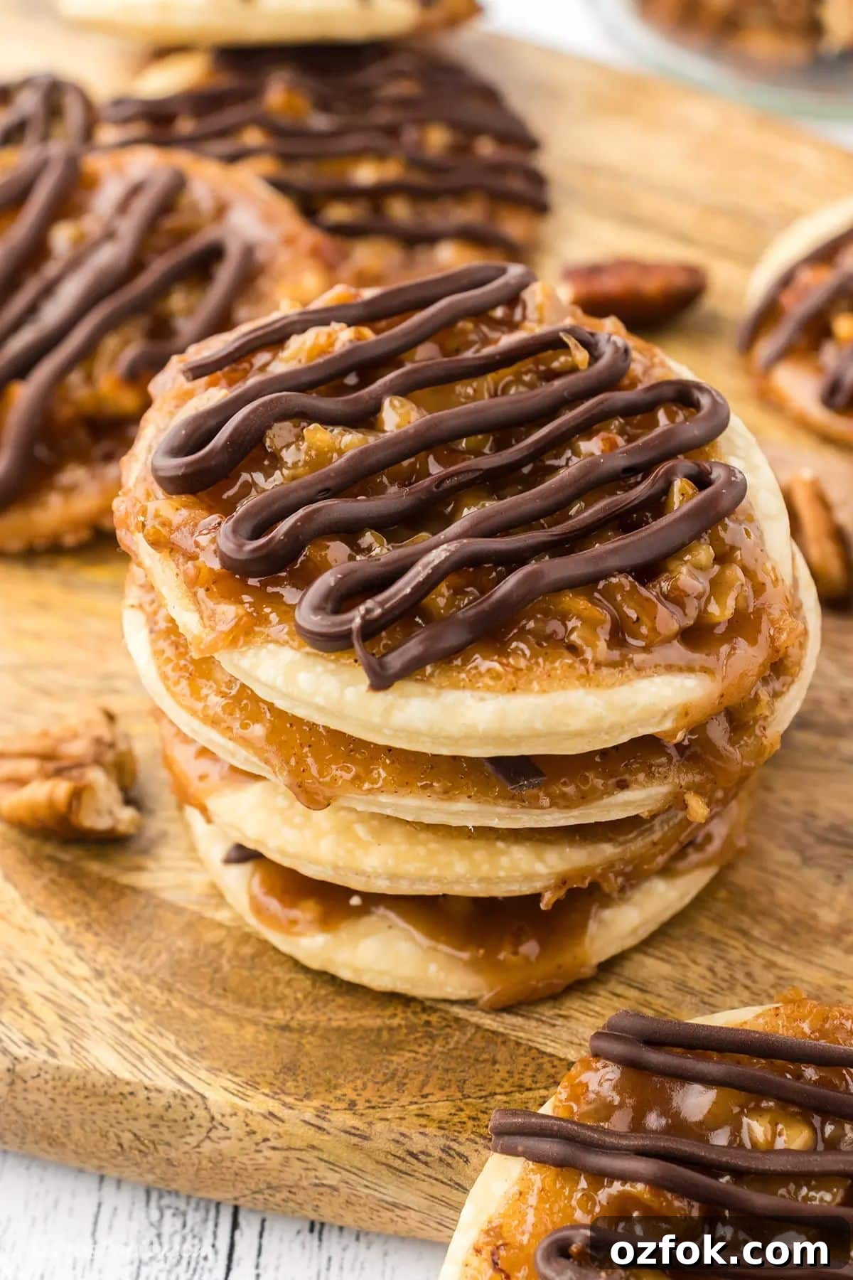 Pecan Pie Cookie Recipe: Chewy Cookies with Cinnamon Glaze 2 A stack of pecan pie cookies on a wooden board.